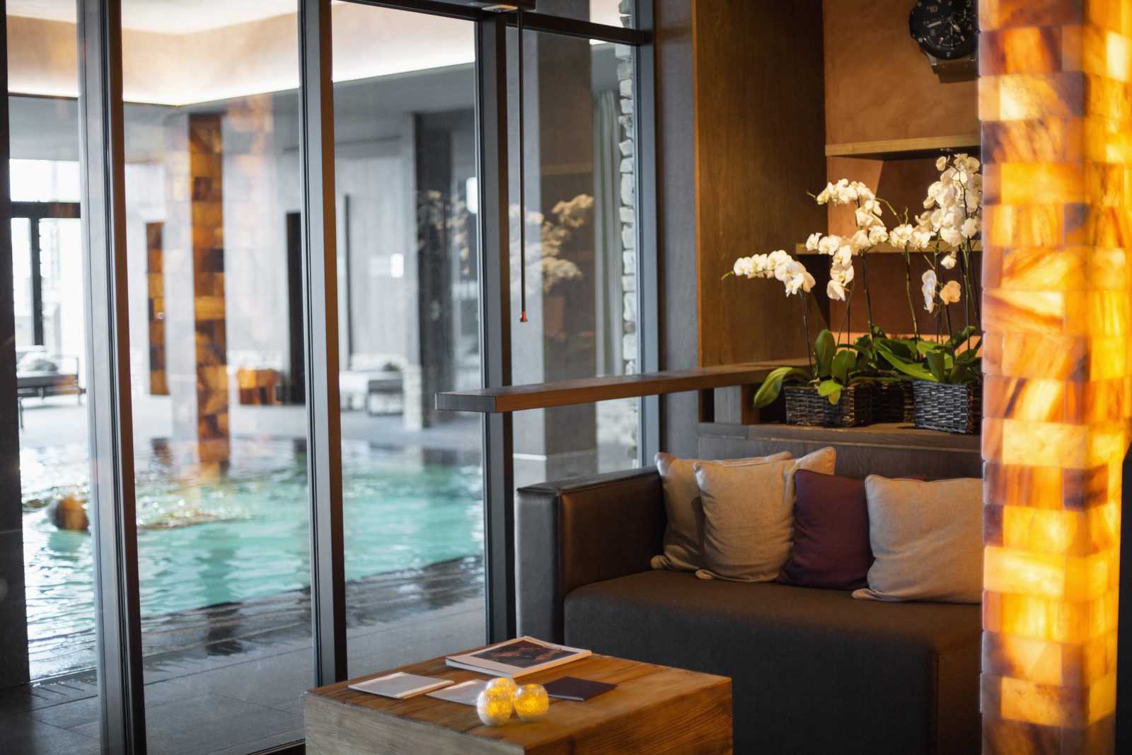 Otel lobisi — kapalı havuz, orkideler ve oturma alanı